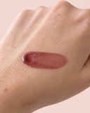 Salty Gal lip gloss swatch on skin — nude mauve