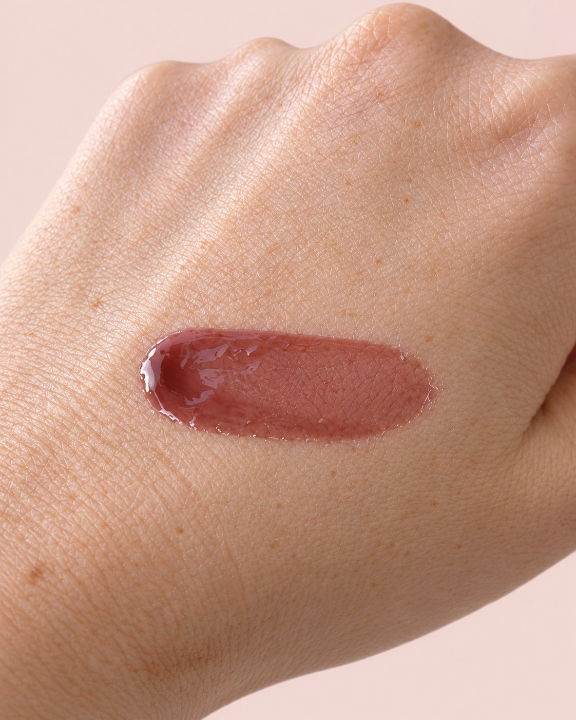 Salty Gal lip gloss swatch on skin — nude mauve